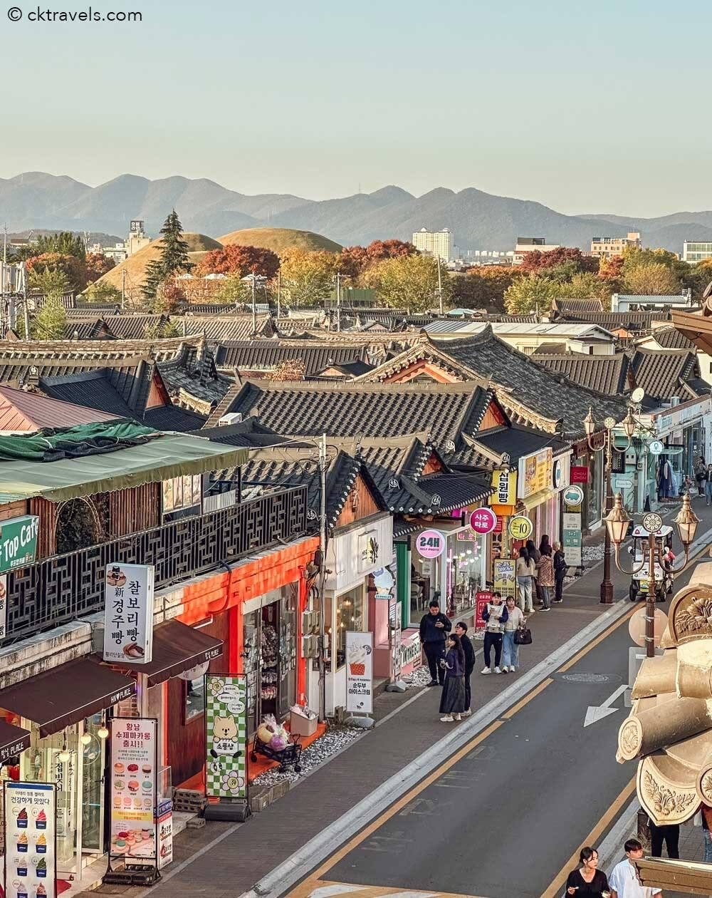Calle Hwangridan-gil con tiendas hanok y túmulos reales al fondo, Gyeongju