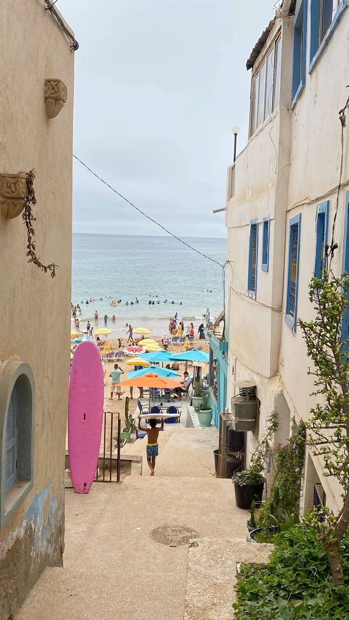 Callejón de Taghazout bajando a la playa con una tabla de surf